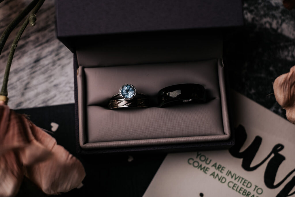 engagement ring and wedding ring for bride and wedding band for groom in a gray ring case