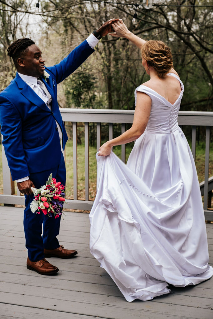 groom twirling the bride while holding her bouquet