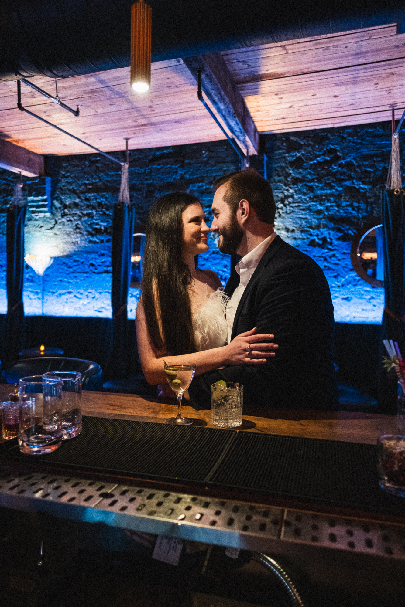 engaged couple embracing at the bar of a speak easy in downtown opelika alabama