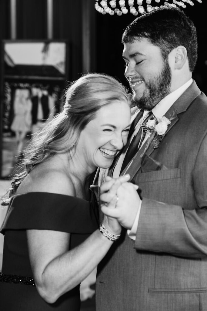 A groom and his mom having a fun time during the mother son dance at a wedding reception