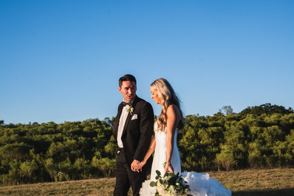 Groom leading his bride by the hand on their wedding day as they move into the next moment of their day.